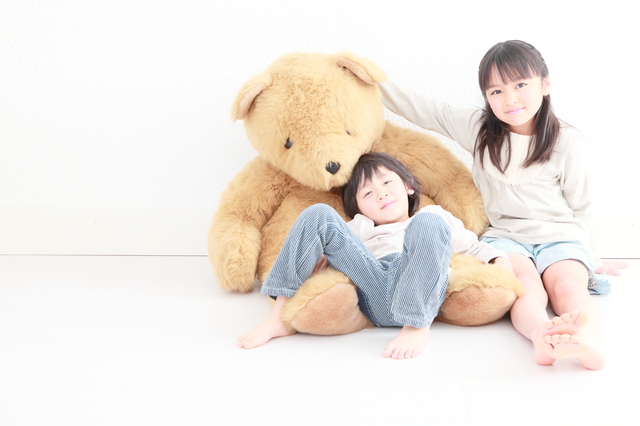 大きなクマのぬいぐるみと2人の子供