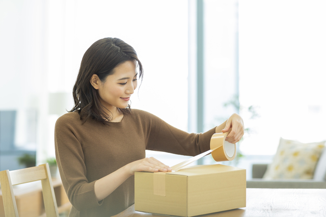 箱をパッキングしている女性