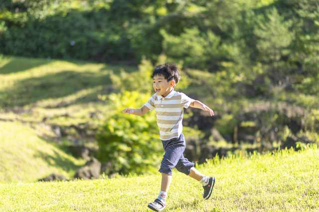 芝生の上を走る男の子