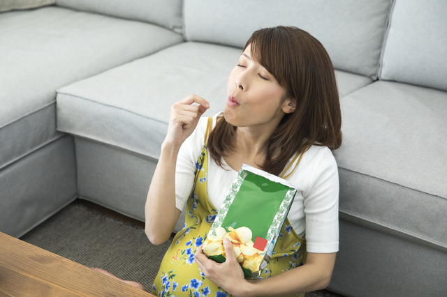 お菓子を食べる妊婦