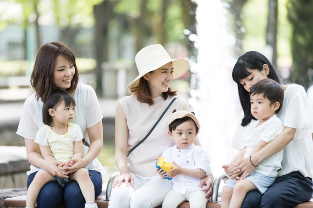 公園で談笑するママ友と子どもたち