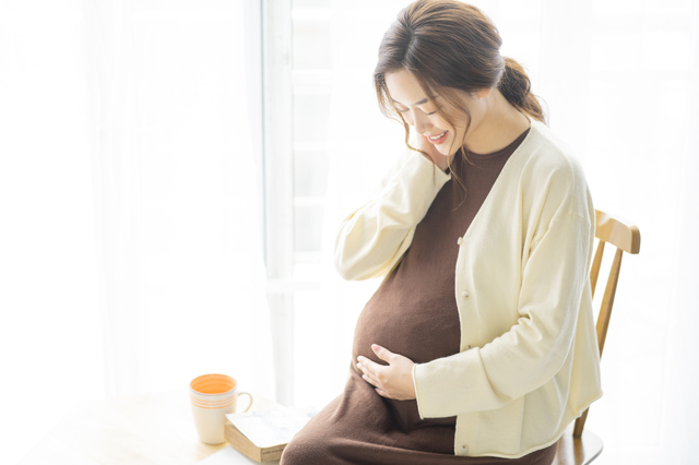 お腹を見る妊婦