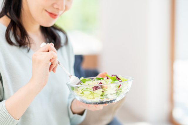 サラダを食べている女性