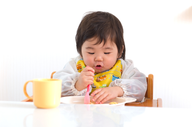 スプーンで離乳食を食べる赤ちゃん