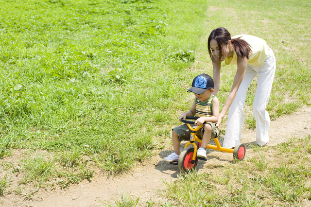 三輪車を教えるママと子ども