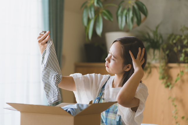 子ども服を手に取る女性