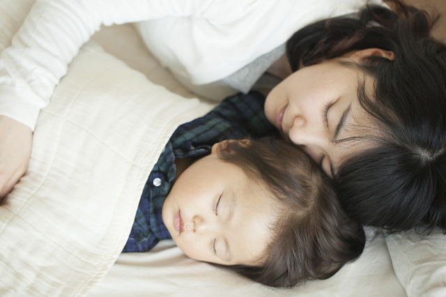 眠っている母親と子ども