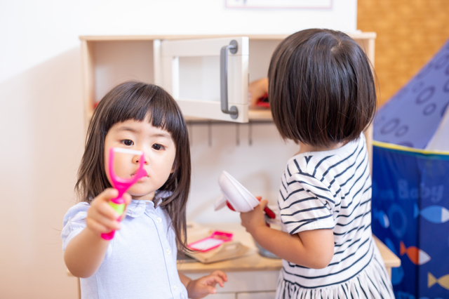 キッチンのおもちゃで遊ぶ2人の女の子