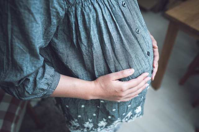 お腹に手を当てる妊婦