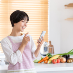 キッチンでスマホを操作する女性