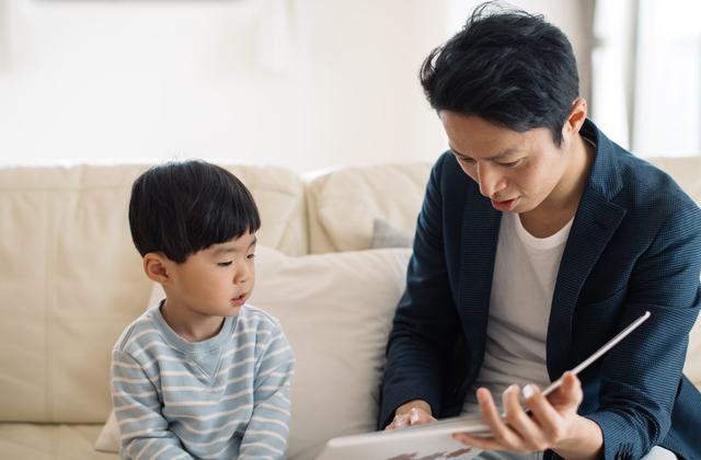 子どもに読み聞かせするパパ