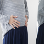 お腹を抑える女性