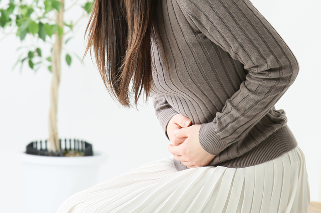 お腹を抑える女性