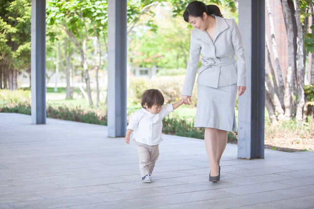 子どもの手を引くママ