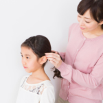 子供のヘアアレンジをするママ