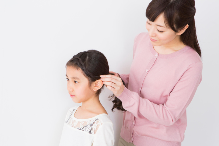 子供のヘアアレンジをするママ